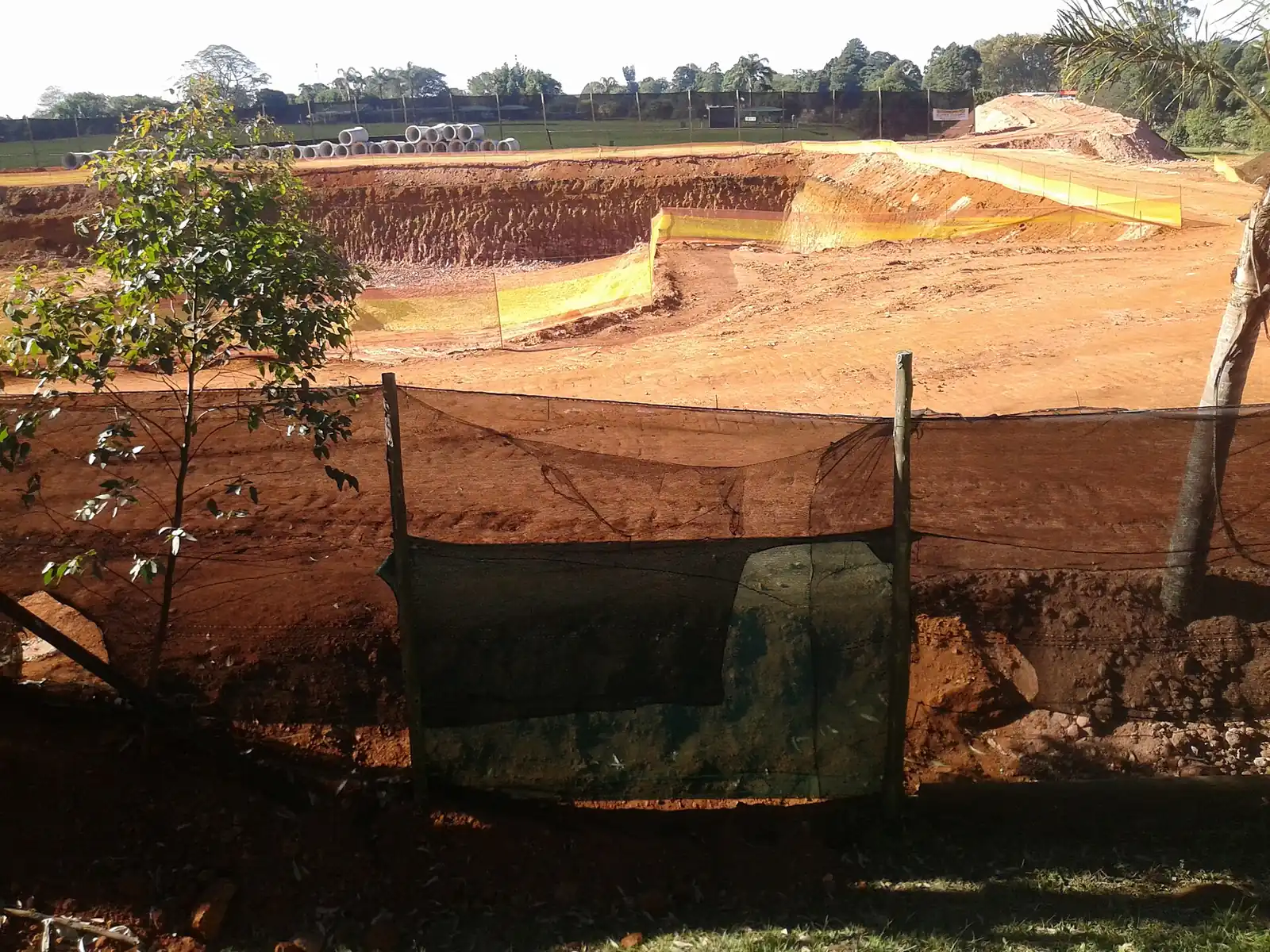 An excavator bucket digging into subsoil on a cleared building site
