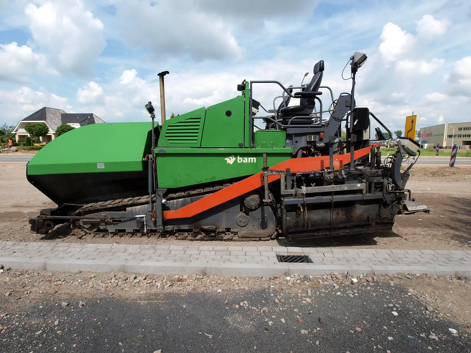 An asphalt paving machine laying hot mix on a new surface
